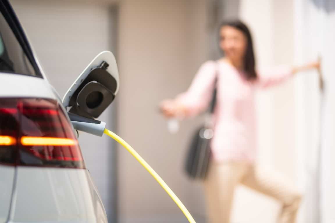 femme qui recharge sa voiture électrique à domicile